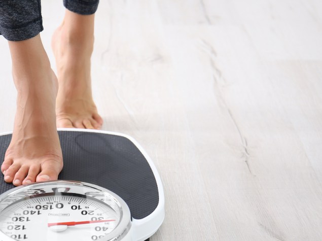 piedi nudi di donna che salgono su una bilancia