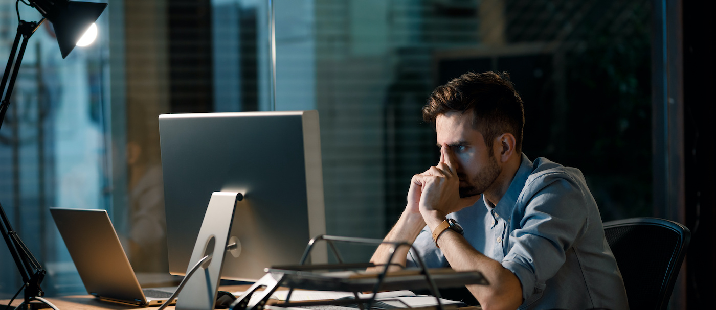 ragazzo di fronte al monitor del suo computer con le mani conserte