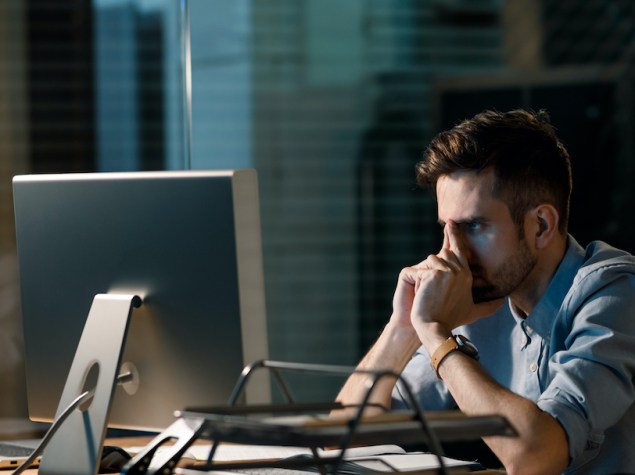 ragazzo di fronte al monitor del suo computer con le mani conserte
