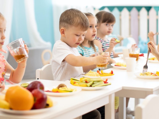 Gruppo di bambini che mangiano cibo sano all'asilo