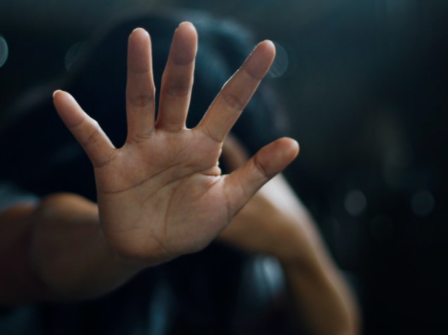 ragazzo che allunga la mano aperta verso l'osservatore, come gesto di allontanamento