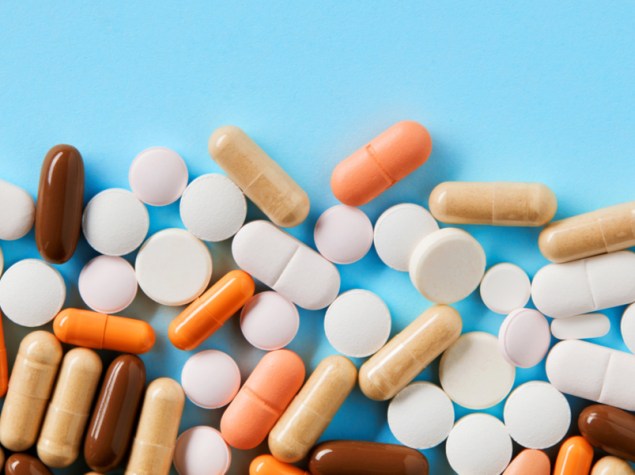 farmaci in pillole e pasticche su sfondo azzurro