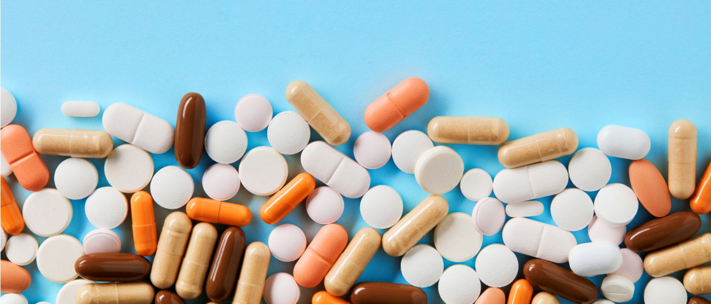 farmaci in pillole e pasticche su sfondo azzurro
