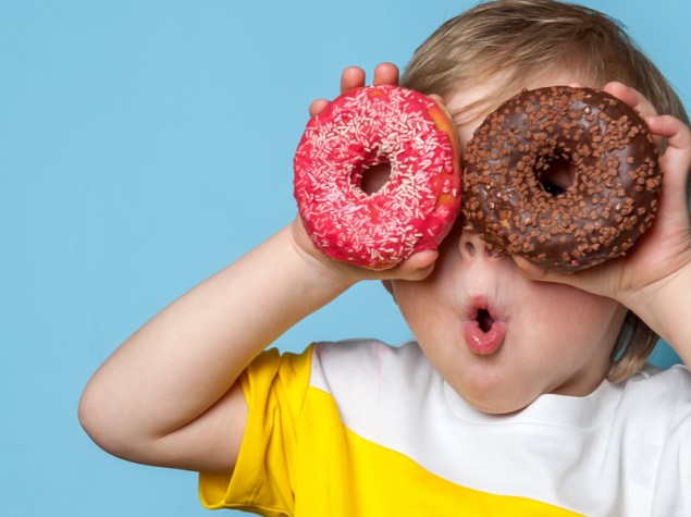 bambino che mette due ciambelle di zucchero davanti agli occhi