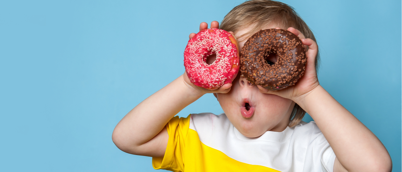 bambino che mette due ciambelle di zucchero davanti agli occhi