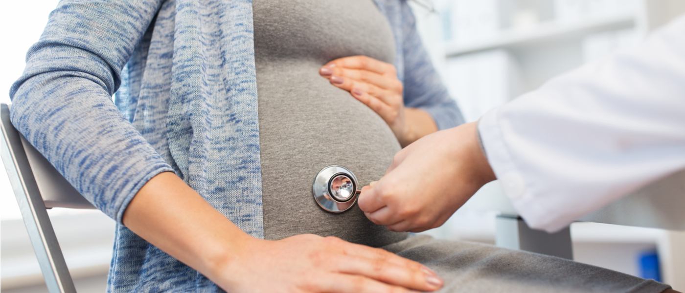 medico che ausculta la pancia ad una donna incinta