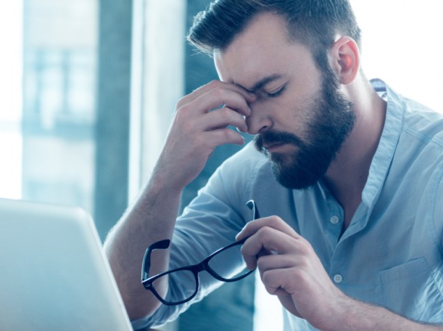 uomo stressato che lavora al computer