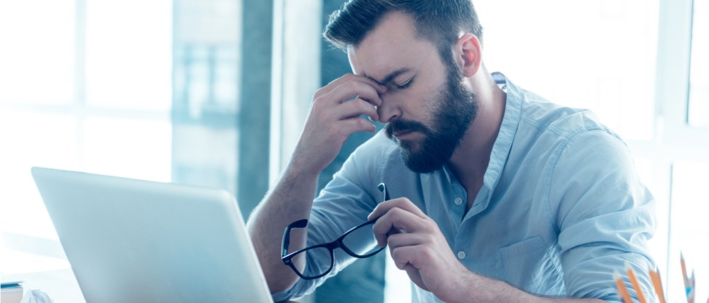 uomo stressato che lavora al computer