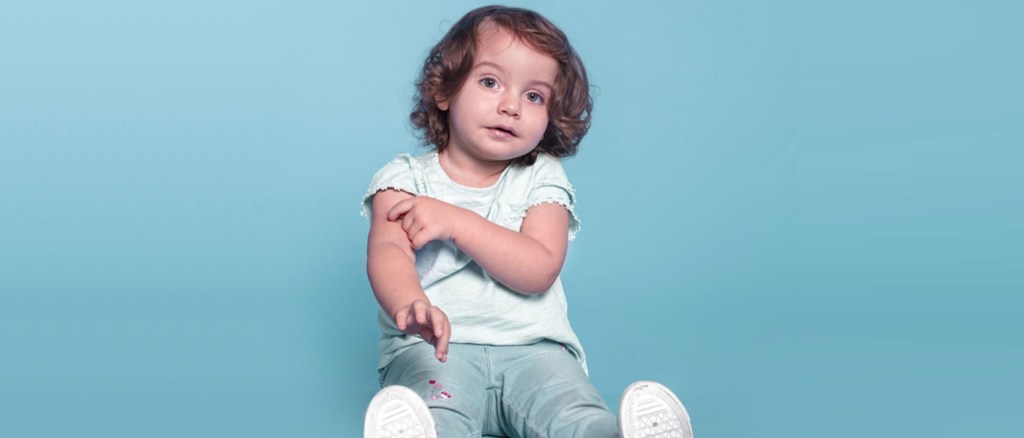 bambino che si tocca il braccio dopo aver ricevuto il vaccino