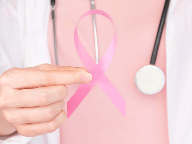 dottoressa che tiene in mano un fiocco rosa, simbolo della lotta al tumore al seno