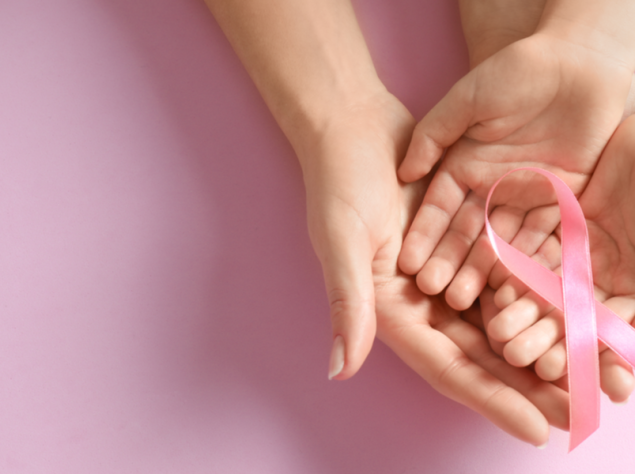 mani di donne che tengono un fiocco rosa