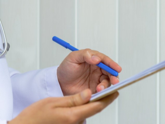 dottore che scrive su una cartella medica