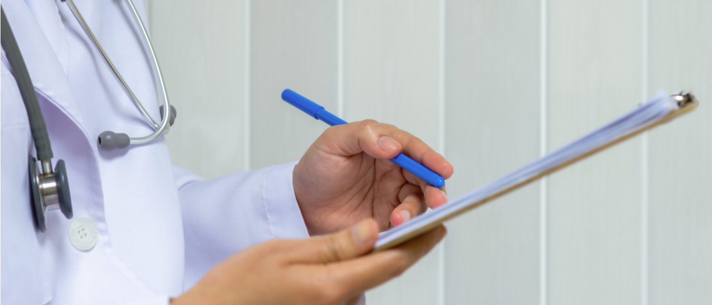 dottore che scrive su una cartella medica