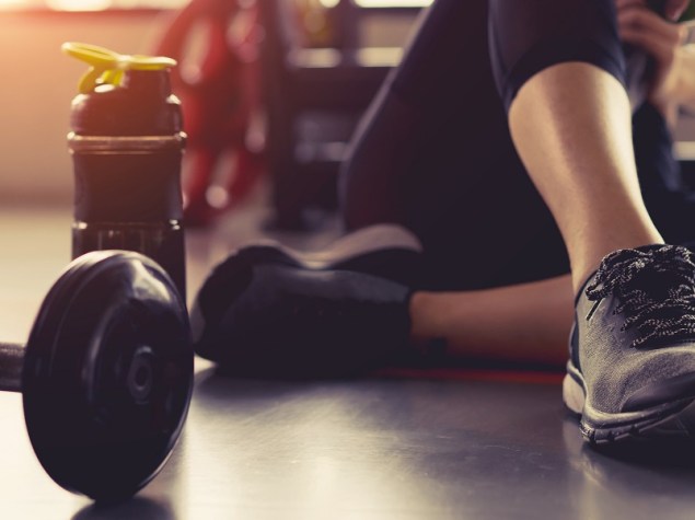 donna seduta a terra vicino a dei pesi