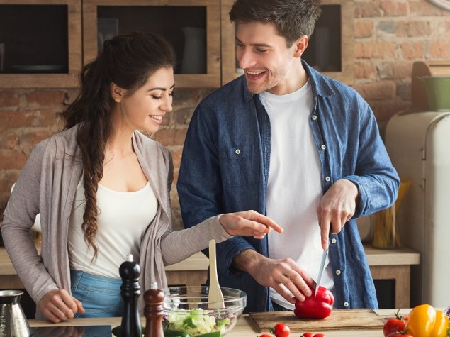 coppia di giovani fidanzati che cucinano un pasto salutare