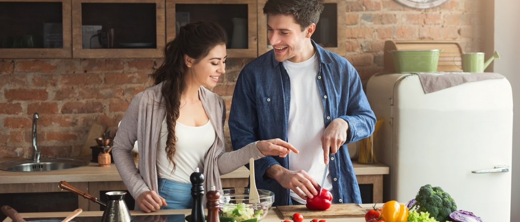 coppia di giovani fidanzati che cucinano un pasto salutare