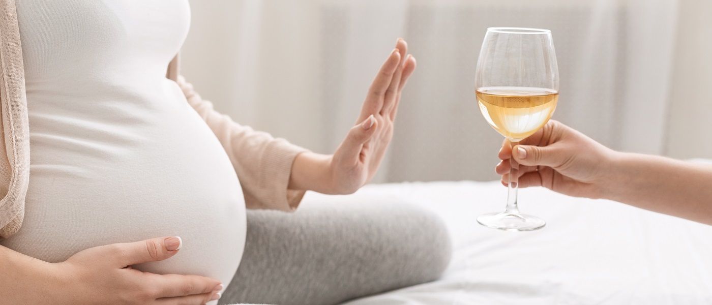donna incinta che rifiuta un bicchiere di vino