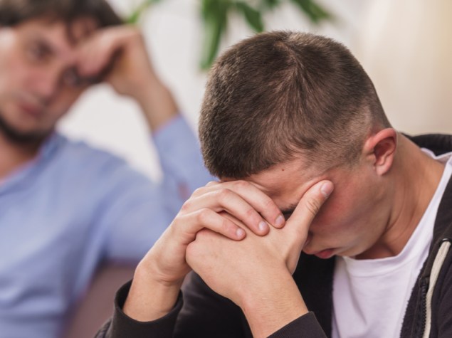 teenager triste seduto sul divano con le man i sul viso