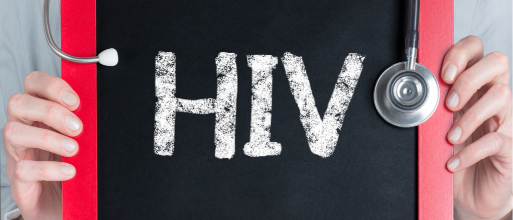 dottore che tiene in mano una lavagna nera con scritto "HIV" in bianco
