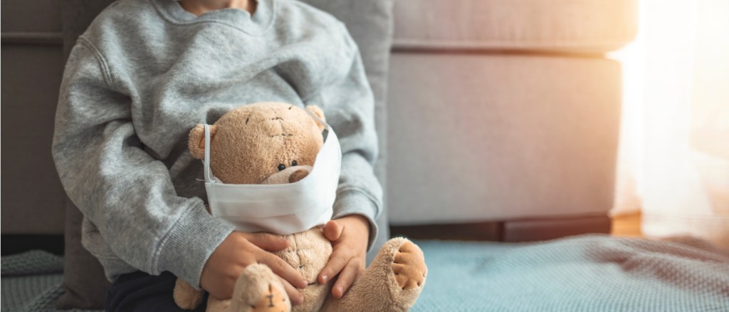 bambino con un peluche con la mascherina