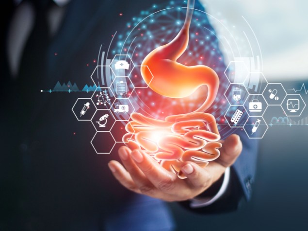 foto di dottore che tiene sul palmo della mano l'ologramma di un intenstino