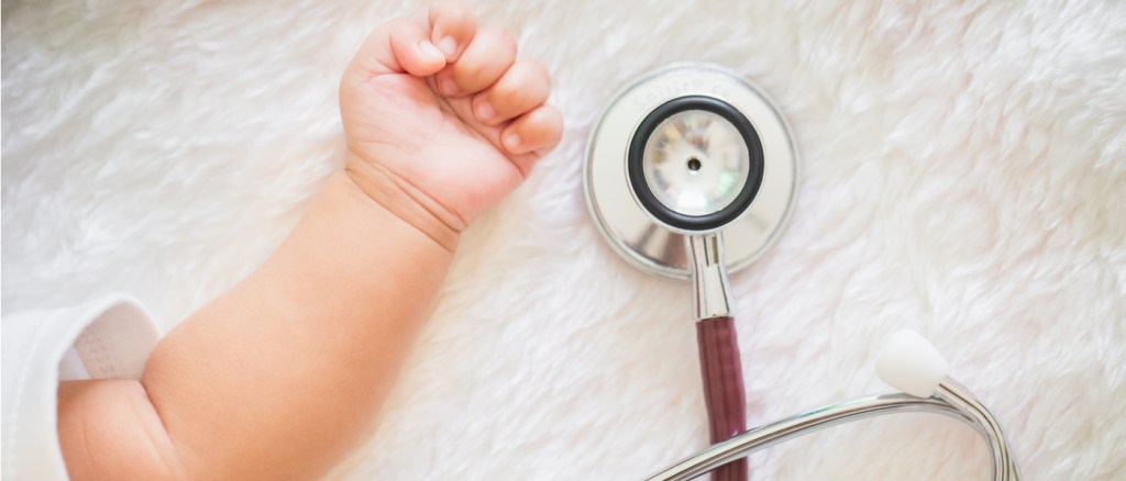 mano di bambino vicino a stetoscopio