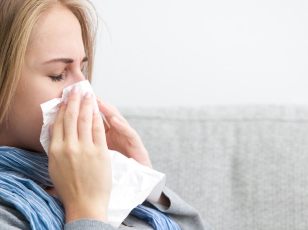 donna seduta che si soffia il naso