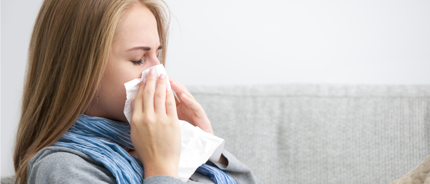 donna seduta che si soffia il naso