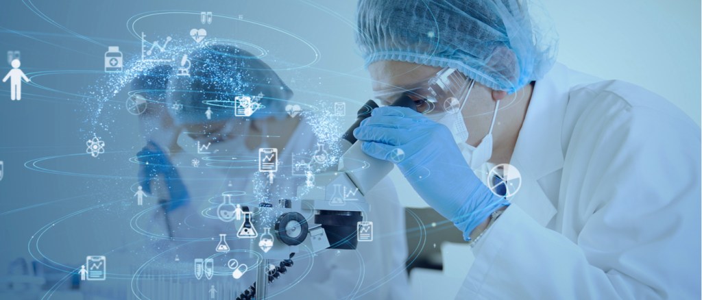 Persona in laboratorio guarda attraverso un microscopio