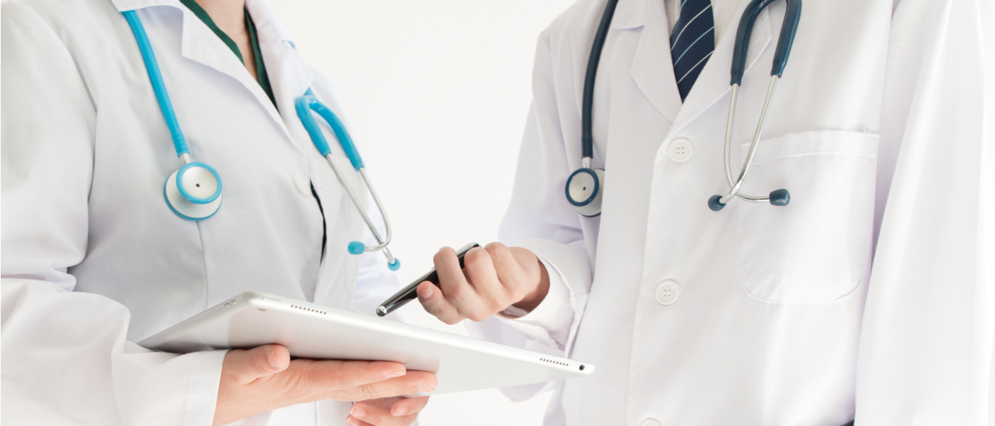 due dottori in piedi che controllano una cartella clinica