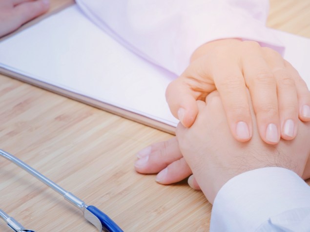 mano del dottore che tiene la mano di una paziente