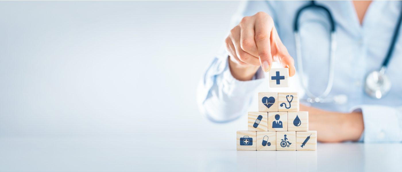 dottore che costruisce una piramide di cubi con disegni inerenti alla medicina