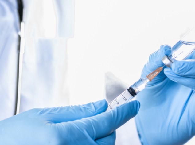 dottore che inserisce una siringa dentro una fila di vaccino