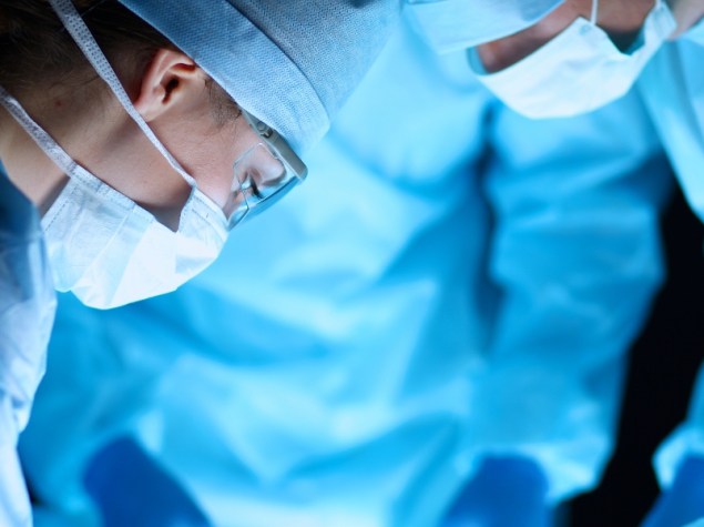 foto di 3 chirurghi che stanno operando