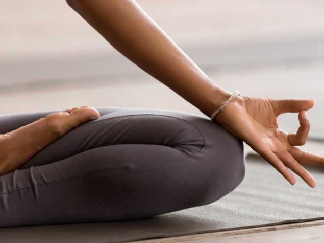 Persona seduta a terra che pratica Yoga