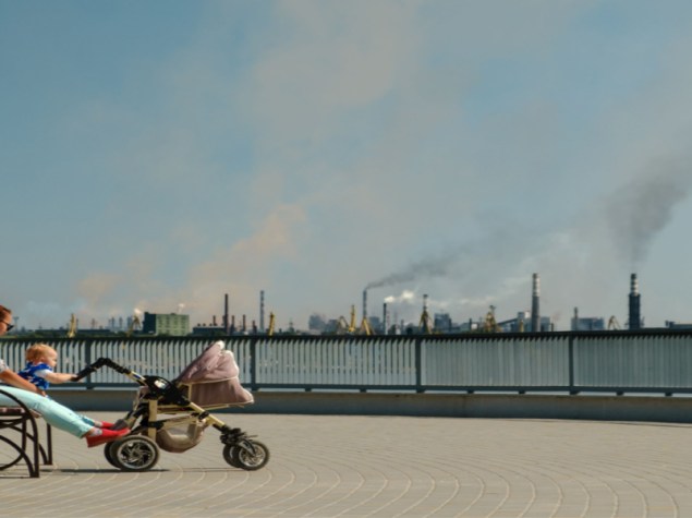 paesaggio di città con ciminiere che emettono inquinamento