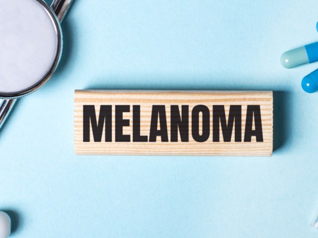 scritta "melanoma" su un tassello di legno
