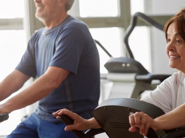 due anziani che fanno pedalano su cyclette