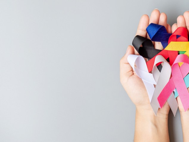 due mani che tengono vari nastri colorati rappresentanti tipologie diverse di tumore