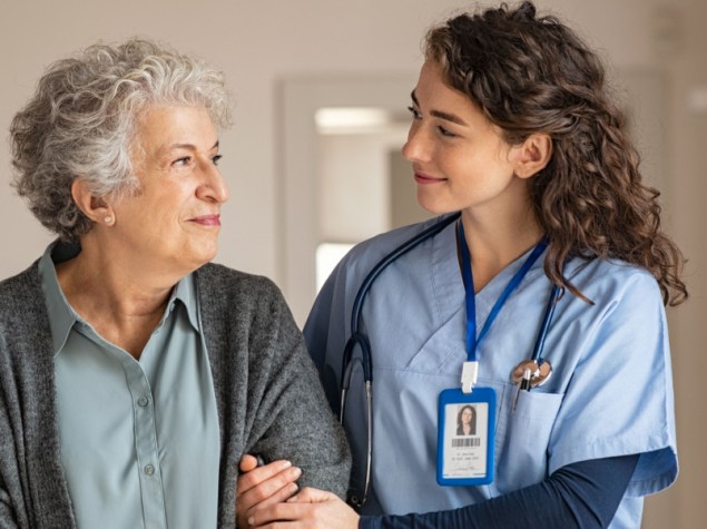 infermiera che porta sotto braccio una paziente anziana