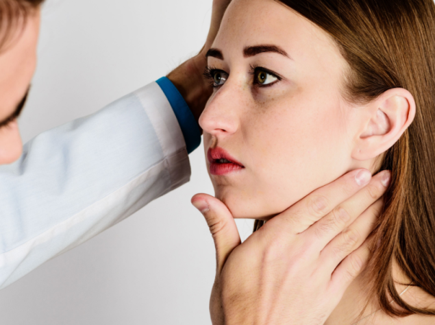 medico che controlla la mandibola di una giovane paziente