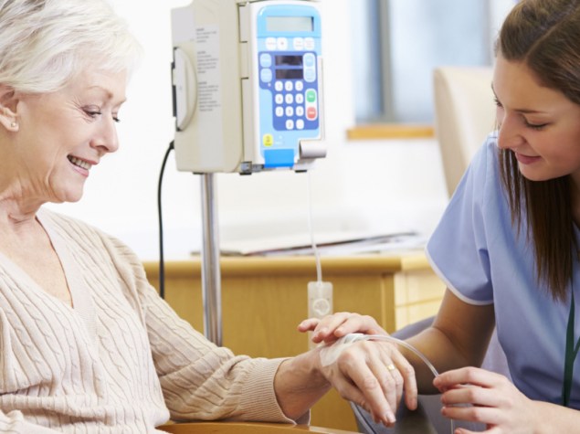 donna anziana esegue chemioterapia mano nella mano giovane dottoressa