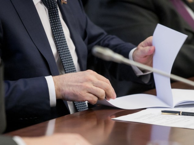 uomo giacca cravatta sfoglia dossier tavolo