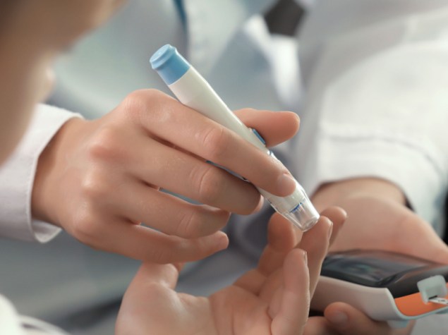 bambino viene punto dal medico con la penna per la misurazione della glicemia