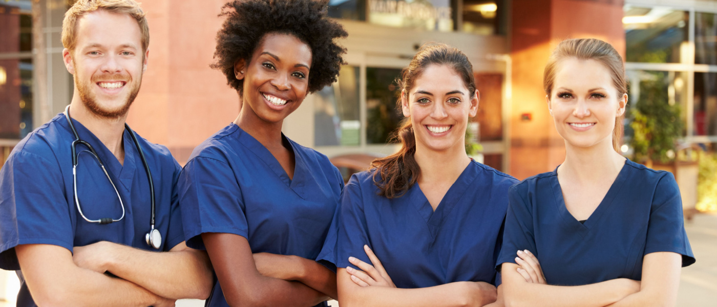 quattro infermieri in piedi sorridendo
