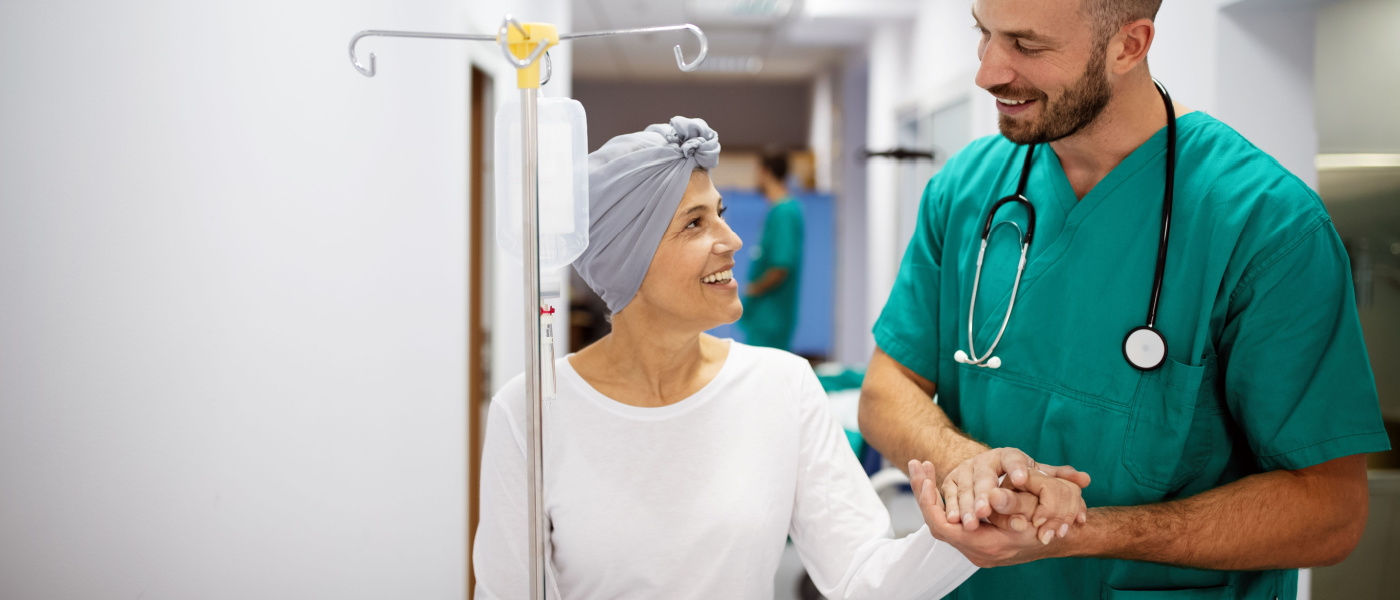 donna che fa chemioterapia cammina e sorride con infermiere