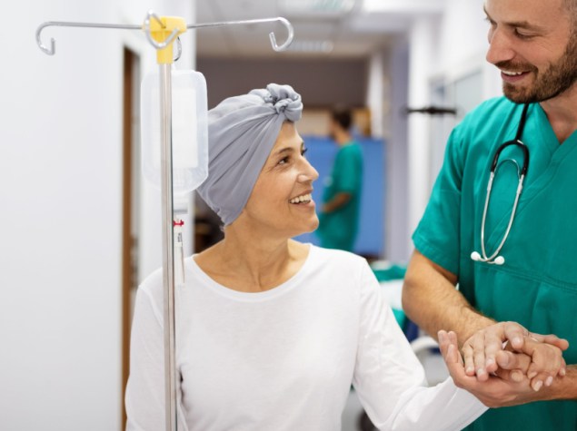 donna che fa chemioterapia cammina e sorride con infermiere