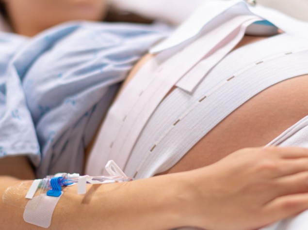 Una donna incinta nella sala parto dell'ospedale con una flebo. Parto e contrazioni.