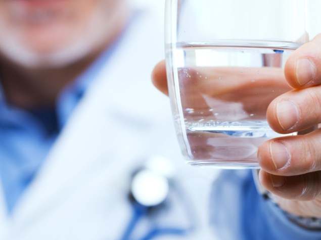 dottore che porge bicchiere d'acqua