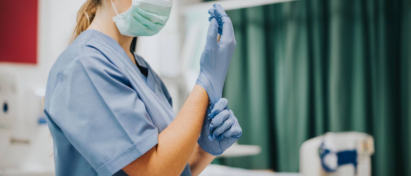 Infermiera senza volta si mette un guanto